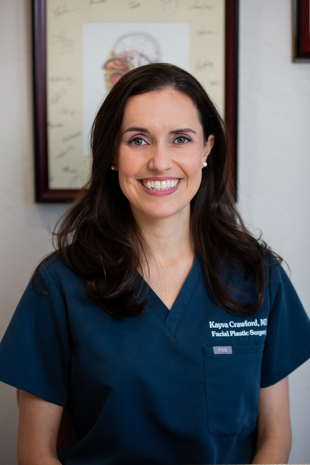 Female doctor smiling in medical attire.
