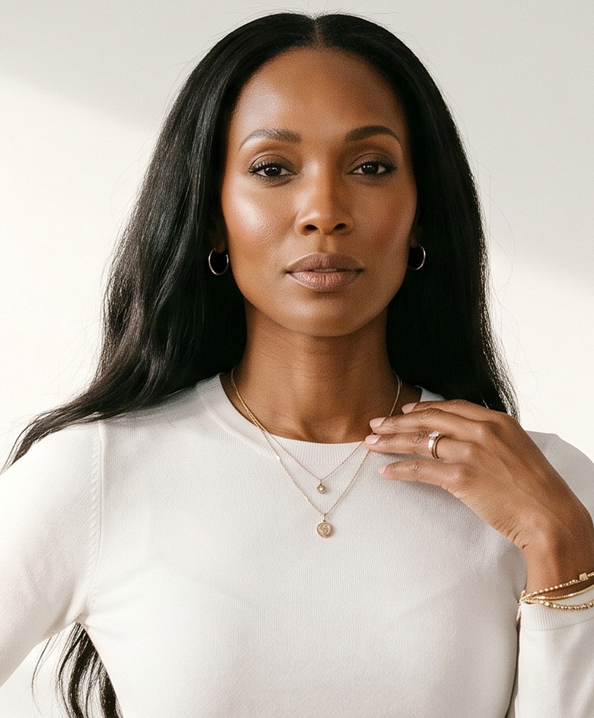 Woman showcasing elegant jewelry and natural beauty.