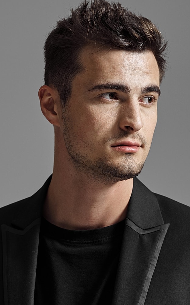 Man in suit against gray background.