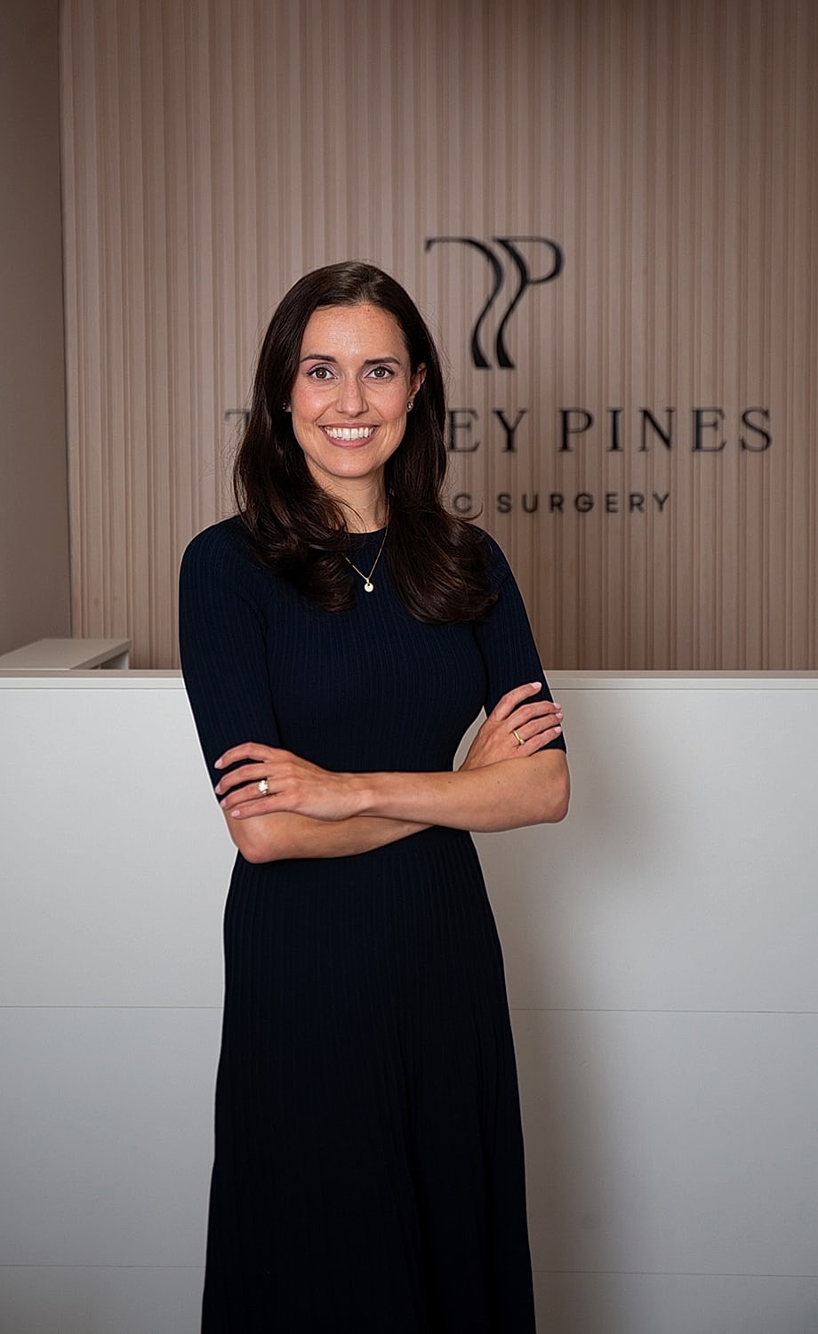 Smiling woman in professional setting with logo.