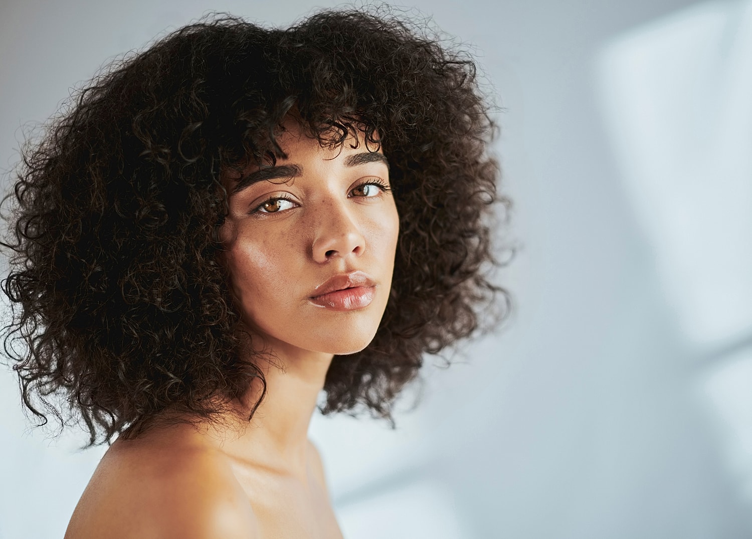 Close-up of a woman with curly hair.