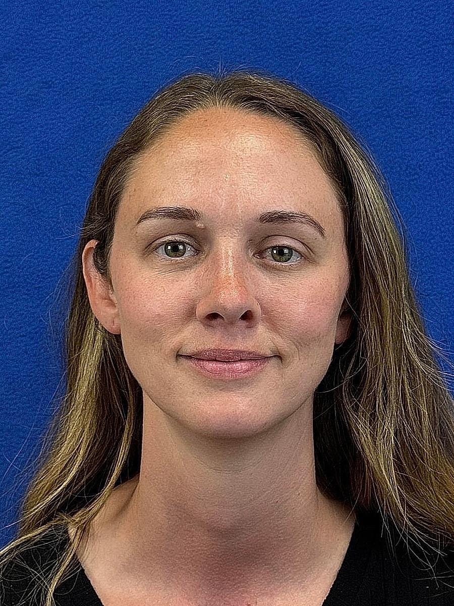 Woman with long hair in front of blue background.