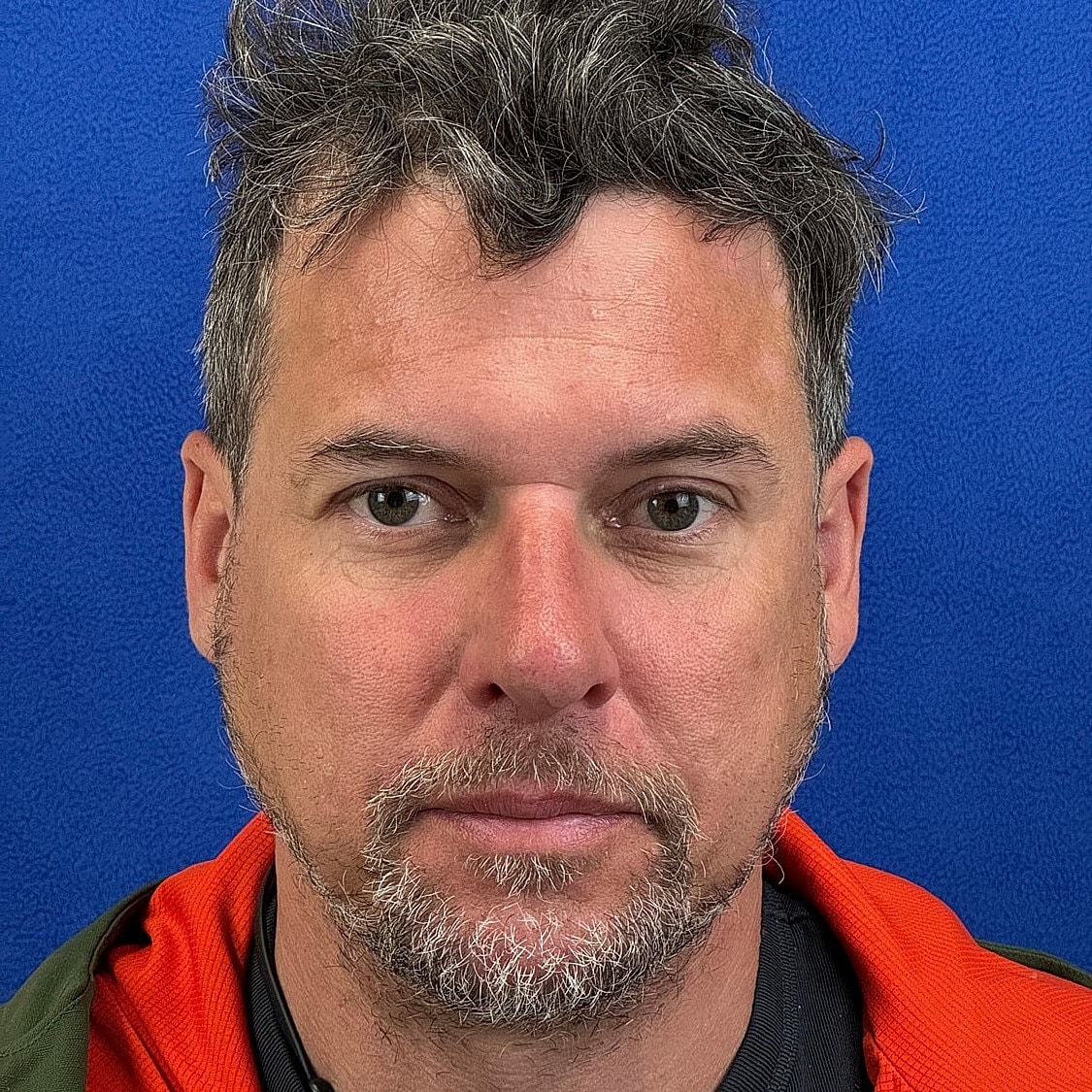 Man with tousled hair against blue background