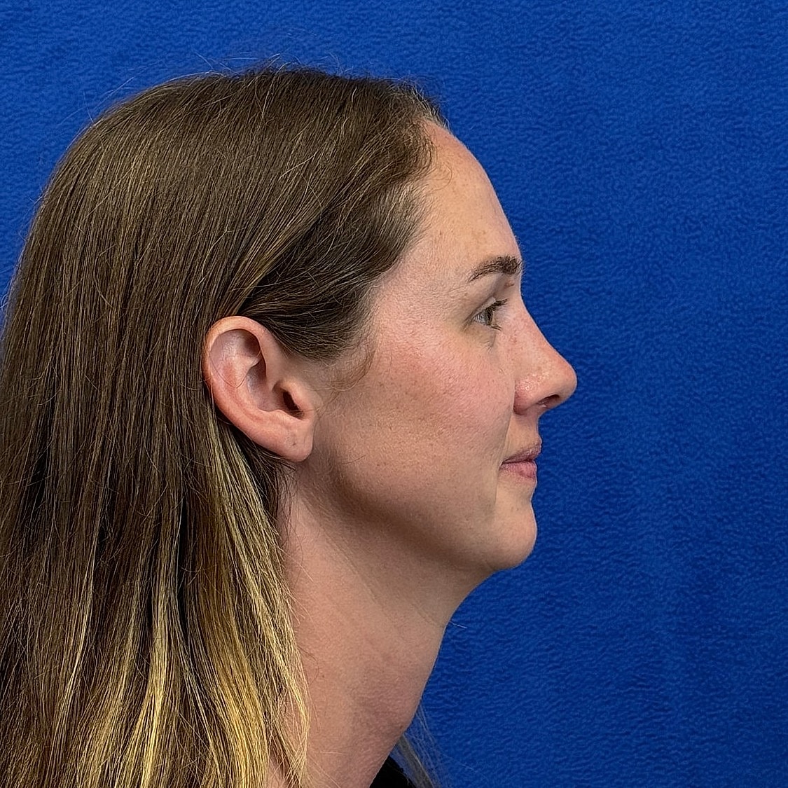 Profile view of a woman against blue background